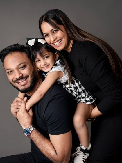 A classic piggyback pose that is always full of smiles. This family portrait against a solid grey backdrop is both fun and timeless.