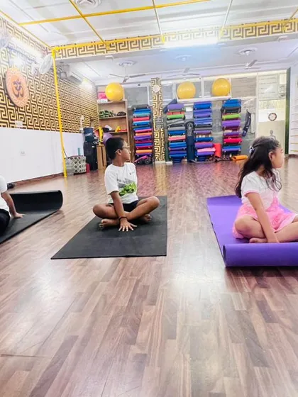 Children learning a gentle seated spinal twist. These poses are great for improving posture and keeping the spine healthy, especially for kids who spend time sitting at desks.