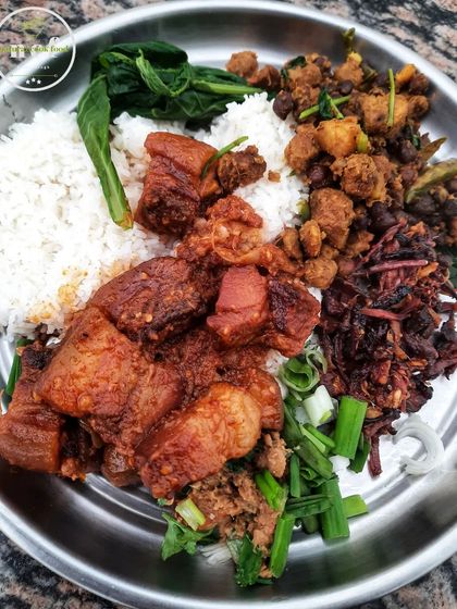 A satisfying plate of smoked pork with rice and other traditional side dishes. The smoky flavor of the pork is the star of this meal.