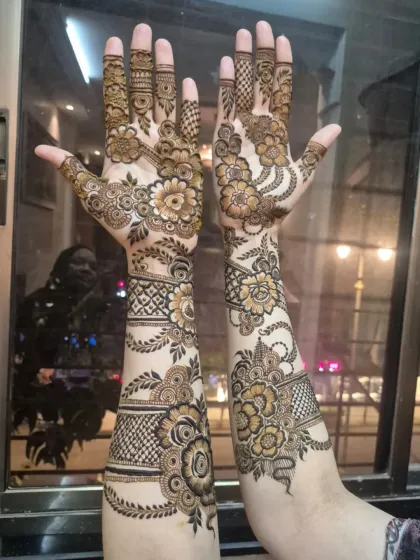 The same intricate floral design shown with palms open, highlighting the detailed work on the fingers and the beautiful flow from the palm to the arm.