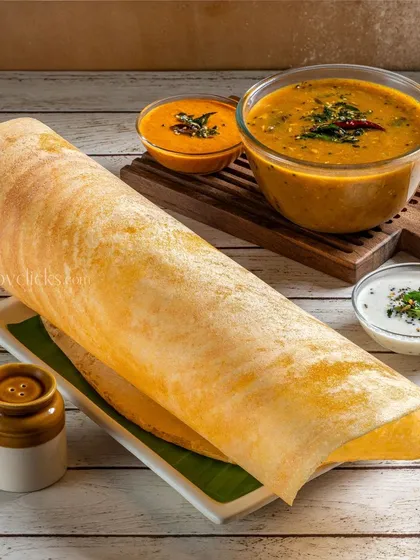 A large, paper-thin dosa served with sambar and chutney for Gulab Sweets. The styling is clean and highlights the impressive size of the dosa.