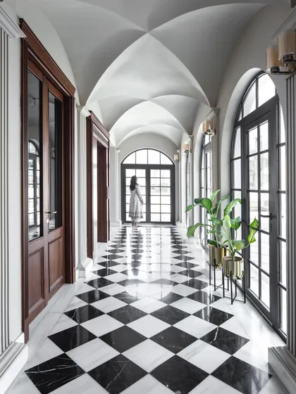 The grand corridor of the Wanderlust Villa, with its vaulted ceiling and checkerboard marble floor, is a testament to our love for creating architectural moments that are both dramatic and elegant.