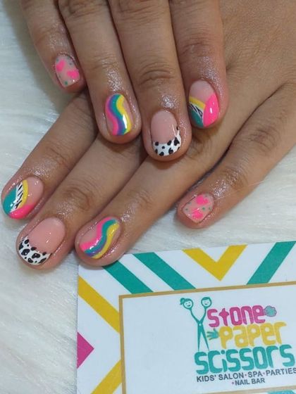 A burst of color on natural nails. This design features rainbow swirls, dalmatian spots, and bright color blocks, showing how much fun you can have even without extensions.