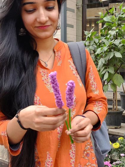 A customer holding the two crochet lavender stems.