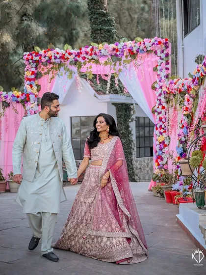 The couple walking hand-in-hand through the decorated entrance of their engagement venue.