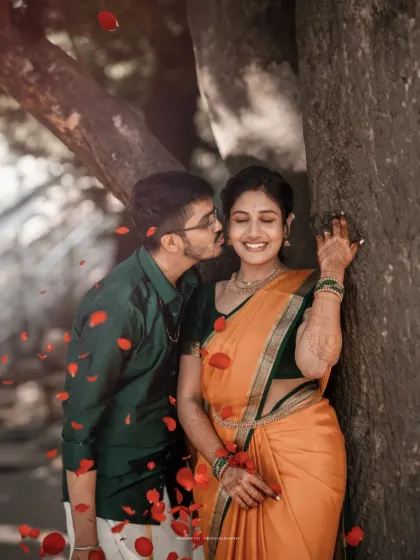 A playful kiss and a shower of petals create a moment of pure joy. This outdoor pre-wedding session was filled with laughter and romance.