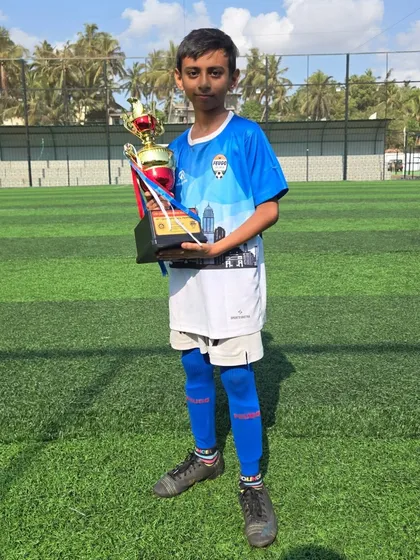 A young player from our U12 squad posing with his winner's trophy.