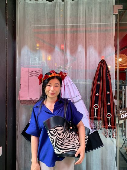 A stylish guest dressed in blue, posing in front of our Tuluni festival decorations.