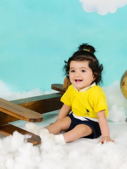 A smiling baby boy is ready for takeoff in his aviator-themed photoshoot.