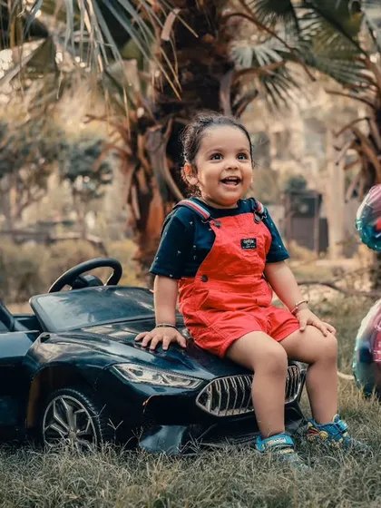 Celebrating a second birthday outdoors with a favorite toy car. We offer outdoor baby photoshoots to capture your child's personality in a natural, open environment.