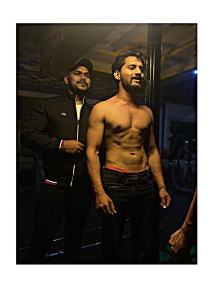 Working together to build a shredded physique. Here I am with a client, checking his progress as he develops lean muscle and six-pack abs.