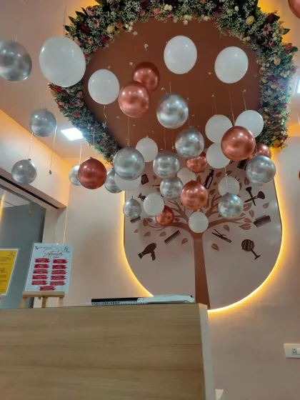 A detailed look at the hanging balloon decor in a salon. The mix of metallic and matte balloons at varying heights adds depth and visual interest to the ceiling space.