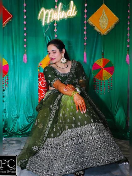 The beautiful bride showing off her Mehndi design. The rich green backdrop I created for her ceremony perfectly complements her stunning green lehenga.