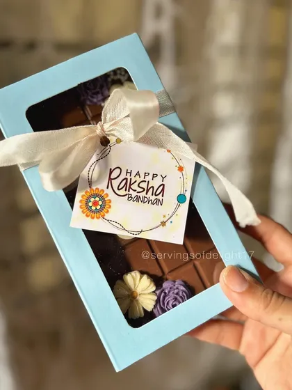 The final presentation of the 'Best Bro' chocolate bar, tied with a ribbon and a 'Happy Raksha Bandhan' tag. It's all in the details.
