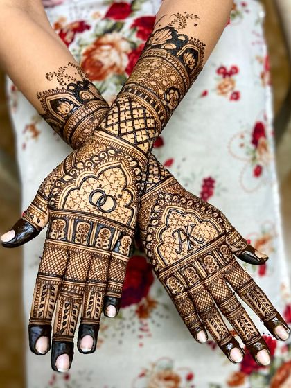 A beautiful design with the couple's initials, 'AK', and wedding rings featured prominently on the back of the hands.