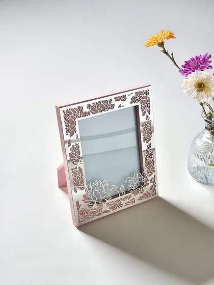 This elegant pink frame with rose-gold floral cutwork is soft, feminine, and sophisticated. It is a beautiful way to add a touch of color and intricate design to your decor.