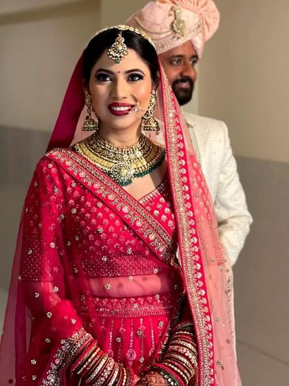 A picture of pure elegance. This bride looks absolutely regal in a heavy gold-plated Kundan choker with green accents and a matching matha patti.