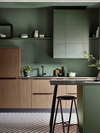 The calming green hue paired with warm wood tones evokes a sense of understated luxury, while clever storage and sleek finishes make for elegant everyday living.