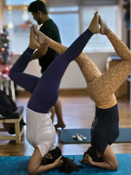 This beautiful partner headstand variation demonstrates the trust, balance, and playful spirit we cultivate within our yoga community.