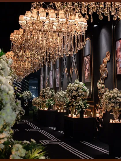 Another perspective of the dramatic entrance, with white floral arrangements providing a soft contrast to the dark, geometric wall panels.