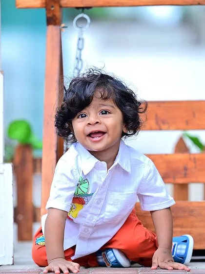 A happy one-year-old boy next to "ONE" blocks during an outdoor shoot.