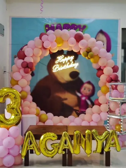 A "Masha and the Bear" themed 3rd birthday party, featuring a circular balloon arch, neon sign, and foil name and number balloons.