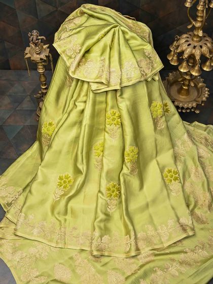 A soft lime green silk saree with delicate floral embroidery. This is a fresh and elegant piece, perfect for daytime events and spring festivities.