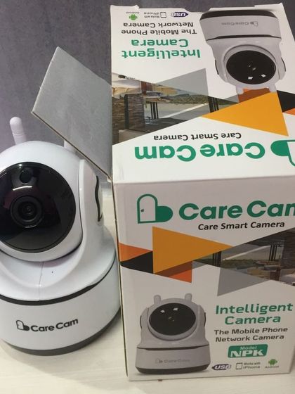 The Care Cam smart camera with its dual antennas for a stable Wi-Fi connection, shown next to its box.