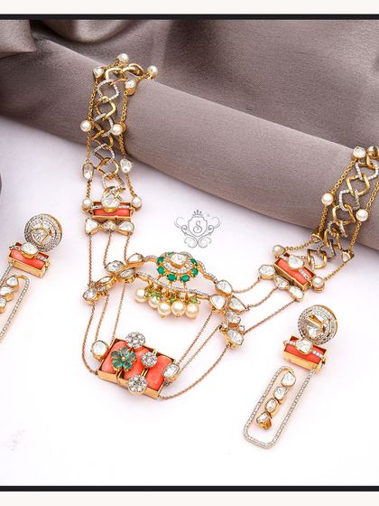 A luxurious and colourful necklace set featuring polki diamonds, pearls, and vibrant coral and emerald green stones. This multi-layered choker is a perfect example of high-end fashion jewellery.