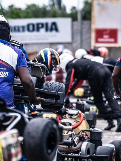 The pit lane is a flurry of activity as teams prepare for the race.