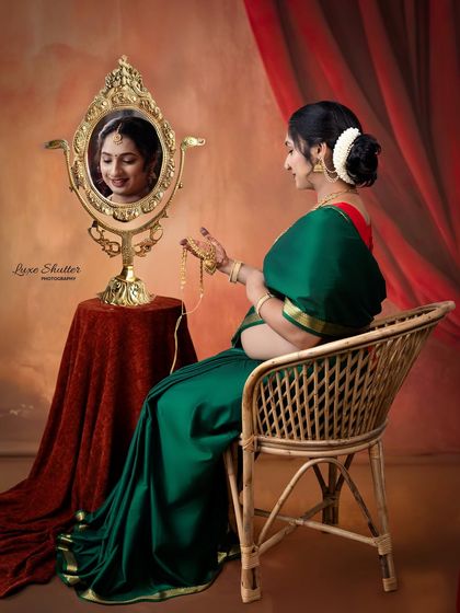 A moment of quiet reflection. The mother-to-be, dressed in a beautiful green saree, admires her reflection in an ornate mirror, a scene filled with grace and anticipation.