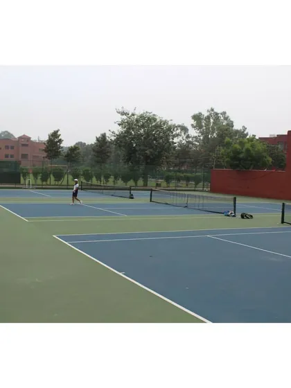 A view across the net during a doubles match, highlighting the layout of our multi-court facility. We provide the complete infrastructure needed to host successful tennis events.