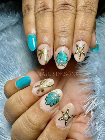 A glamorous take on beach nails. This set features turquoise glitter polish and nude accent nails with golden, hand-painted palm trees, shells, and starfish.