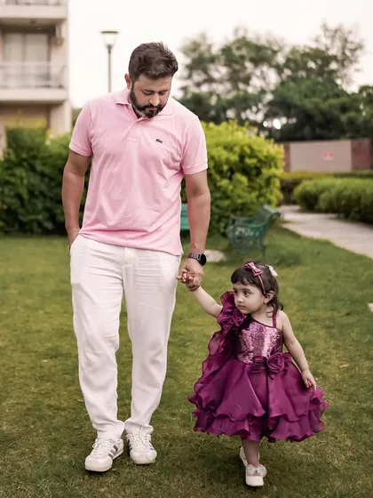 A father and daughter walk hand-in-hand through a park. I focus on capturing these simple, heartfelt connections that define your family's bond.