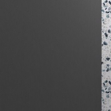 The junction of the plain grey wall and the patterned terrazzo, showing a clean design transition.