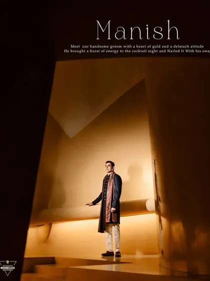 A dramatic and stylish portrait of the groom in a modern, architectural space. The lighting and composition create a powerful, high-fashion look.