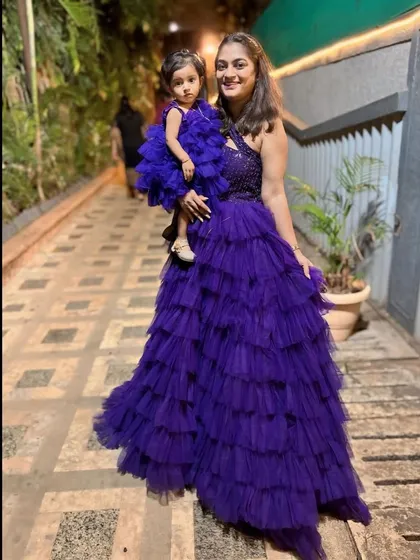 This stunning royal purple layered gown set is perfect for making a statement. The mother's gown features a hand-embroidered bodice, perfectly complemented by the daughter's matching dress.