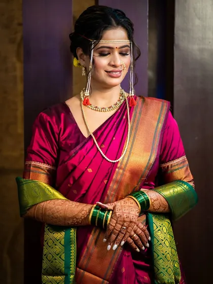 A serene portrait of our Maharashtrian bride. Her eyes are softly defined, and her skin has a natural glow that complements the rich silk of her saree.