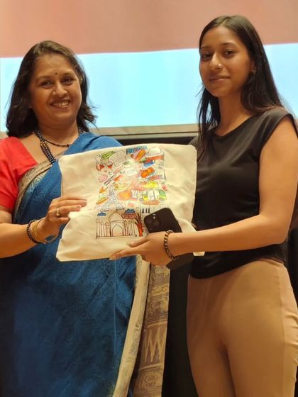 Another student receives her prize on stage, smiling warmly. Our award ceremonies are a joyful part of our community celebrations.