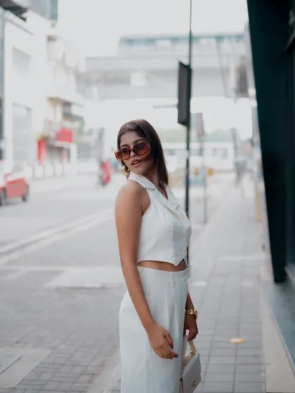 A wide shot of a model in a chic all-white outfit on a city street. This image captures the essence of urban fashion and is great for lookbook content.