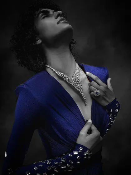 A dramatic, artistic shot for Purab Paschim, using color selection to highlight a blue dress while keeping the model in black and white to emphasize the diamond necklace.