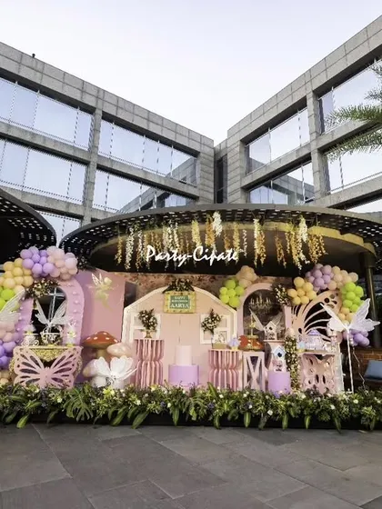 We transformed this beautiful outdoor venue into an enchanted fairy garden. The main stage was designed to look like a magical cottage, surrounded by lush greenery, giant mushrooms, and whimsical lighting to create a truly special atmosphere.