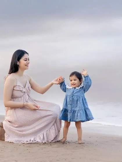 A happy dance by the ocean! This photo perfectly captures the joyful spirit of this mother-daughter duo during their beach photoshoot.