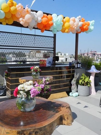 The rooftop bar area is decorated with a colorful balloon garland and pennant flags, extending the festive bunny theme throughout the entire venue.