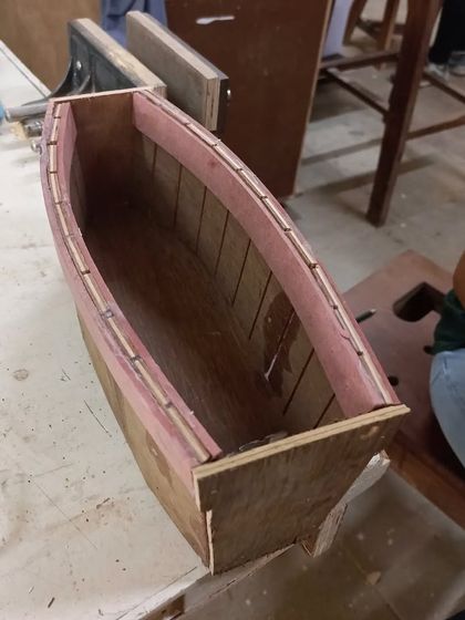 A close-up of the kerf-bent boat. You can see the vertical slits on the inside that allow the plywood to take on this curved shape.