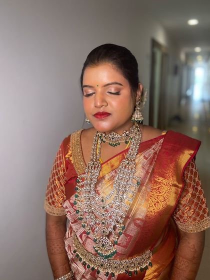 A close-up of the reception makeup. The soft shimmer on the eyes and the bold red lip create a classic glam look that is perfect for any evening event.