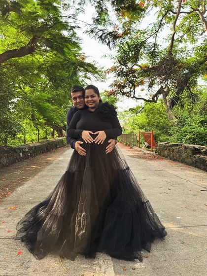 This black tiered gown combines comfort and style with its full-sleeved top and voluminous net skirt. It's a versatile piece that works for both studio and outdoor shoots.