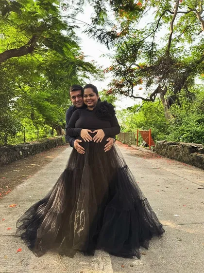 This black tiered gown combines comfort and style with its full-sleeved top and voluminous net skirt. It's a versatile piece that works for both studio and outdoor shoots.