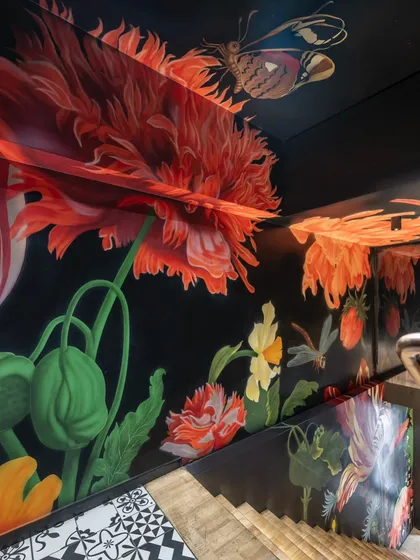 This hand-painted floral mural transforms a restaurant staircase into an immersive journey. Each step invites you deeper into a blooming world, setting a dramatic and enchanting mood before the dining experience even begins.