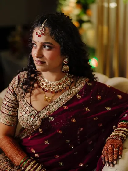 A beautiful profile shot that highlights the soft curls and the flawless finish of her makeup.